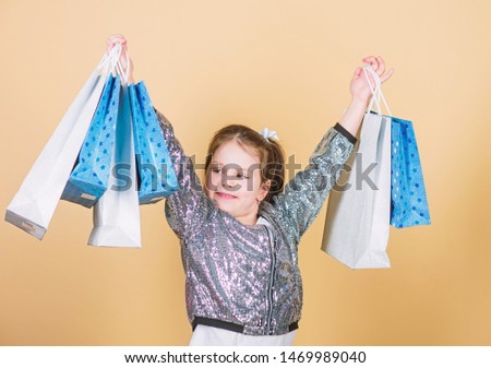 Shopping and purchase. Black friday. Sale discount. Shopping day. Child hold bunch packages. Kids fashion. Surprise gift. Inspiring store to buy more. Girl with shopping bags beige background.