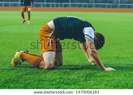 The player of the football team is kneeling on . The game of football.
