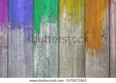 Wooden colorful background texture with paint partly covering planks.