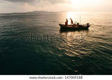 Fisherman on boat in morning