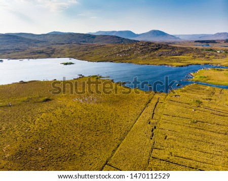 Beautiful aerial sunset view of Connemara region in Ireland. Scenic Irish countryside landscape with magnificent mountains on the horizon, County Galway, Ireland.