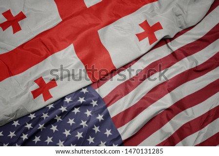 waving colorful flag of united states of america and national flag of georgia.