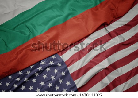 waving colorful flag of united states of america and national flag of bulgaria. macro