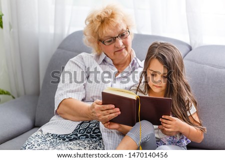 Grandmother and granddaughter reading book