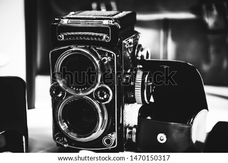 Old twin lens reflex camera and leather equipment in front of the brown leather handbag. Gentleman style photography.
Analog photography machine.

