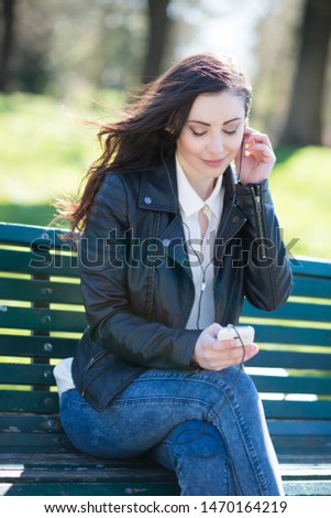 Young woman listening music in a park