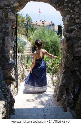 Woman Walking Into a Tropical Garden
