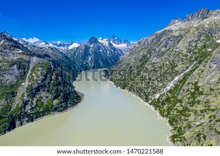 Aerial view over a mountain lake at Grimsel pass in Switzerland - aerial photography