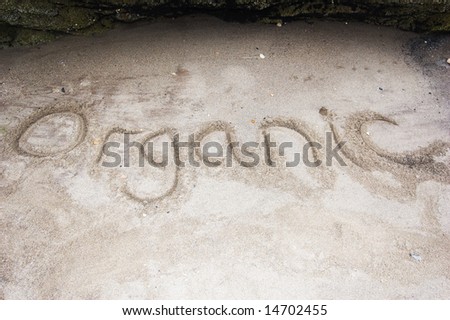 "Organic" handwritten in sand on a beach