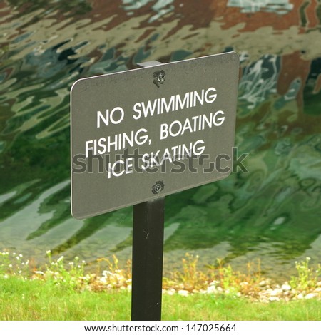 No swimming fishing boating ice skating sign with wavy water in background