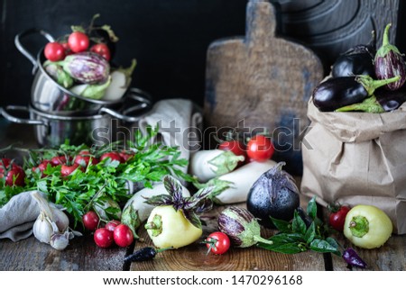 Eggplants of different colors and different grades on a wooden table. Vegetarian menu template.