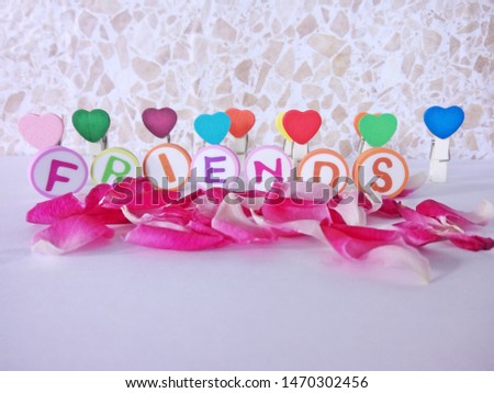'FRIENDS' word background made up from alphabet printed round shape eraser with rose petals