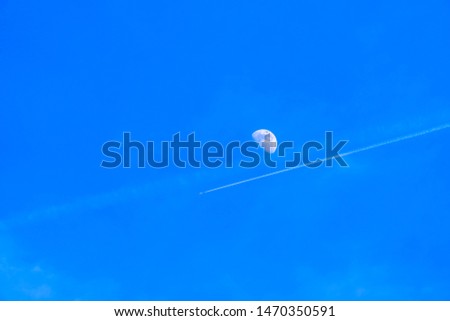 Beautiful view of a moon still visible on the vibrant blue sky during daytime