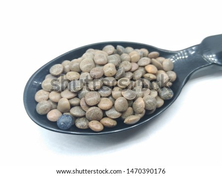 A picture of black lentil on black spoon