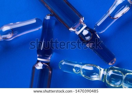Medical ampoules on a blue background. Glass ampoules close up. Medical ampoules.
