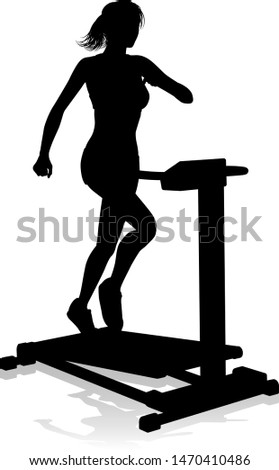 A woman in silhouette using a treadmill running machine piece of gym fitness equipment 