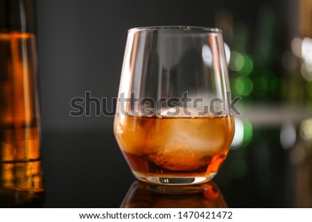 Glass of whiskey on table in bar