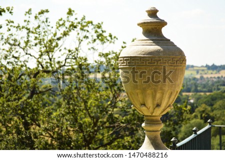 Large stone garden urn in large garden 