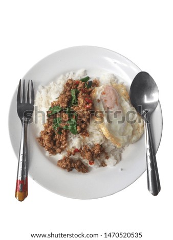 Fried pork with basil and fried egg on disk