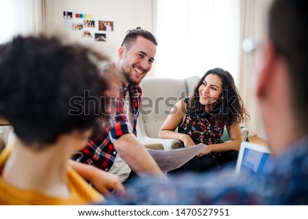 A group of young friends with laptop indoors, house sharing concept. Royalty-Free Stock Photo #1470527951