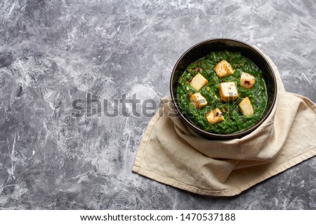 Palak Paneer at grey concrete background. Palak paneer or green paneer - is the indian cuisine vegetarian dish mades of spinach and paneer cheese. Copy space