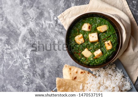 Palak Paneer with chapati and basmati rice at grey concrete background. Palak paneer or green paneer - is the indian cuisine vegetarian dish mades of spinach and paneer cheese. Copy space Royalty-Free Stock Photo #1470537191