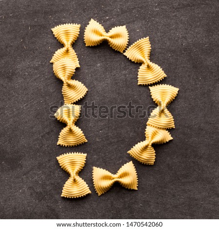 Alphabet made of pasta on gray table background 