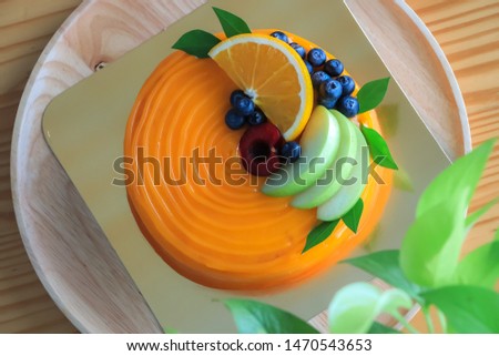 Top view Orange cake (sponge cake) 1 pound,topping fresh fruit, mix berry,Blueberry,Apple slices,Cherry slices,Orange slices and green leaves.