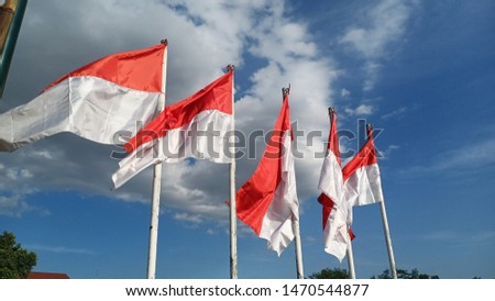The red and white flag flying under the white clouds of blue sky and sunlight, gave the spirit of Indonesia's independence day