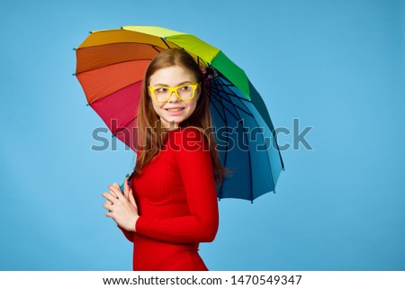  woman in glasses with umbrella on a blue background                              