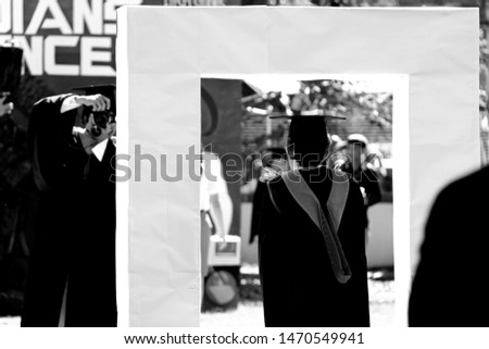 
A photo of a graduate student's bachelor's degree, a man taking a picture for a woman, both very happy, black and white