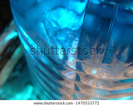 Transparent plastic canister with blue automobile liquid (blue non-freezing liquid) on the porch on the threshold of the house. on the bottle are located transverse swathe of. game of light spots. 