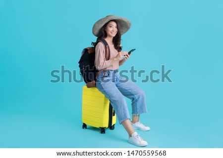 Asian women tourists she is sitting at the airport. She uses a mobile phone. Royalty-Free Stock Photo #1470559568
