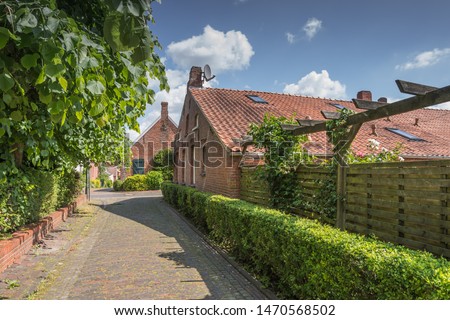 Small Street in Rysum near Emden, East Frisia, Lower Saxony, Germany Royalty-Free Stock Photo #1470568502