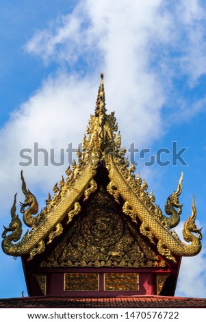 A beautiful wood carving decoration on the tympanum of Wat Phrachao Lan Thong