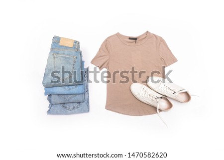 Stack of different blue jeans with brown shirts and white shoes 
