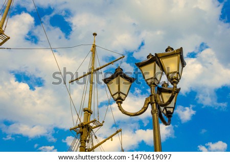 street lights on the background of the mast and blue sky.the mast of the ship on a background of clouds