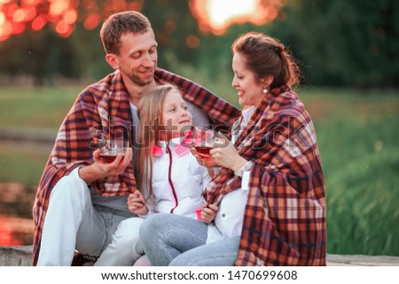 concept of raising children - a happy family wrapped in a blanke