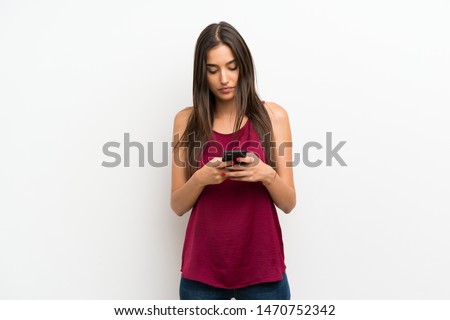 Young woman over isolated white background using mobile phone