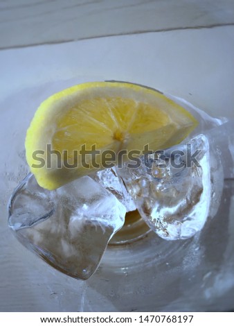 Lemon and ice inside a glass cup