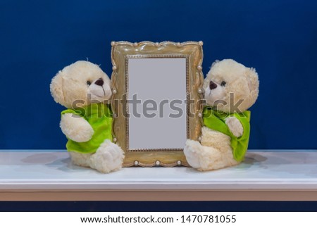 Classic picture frame with little bears doll on the marble table and blue wall decoration