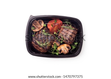 Healthy food. Grill cooked meat steaks with vegetables in delivery box on white background