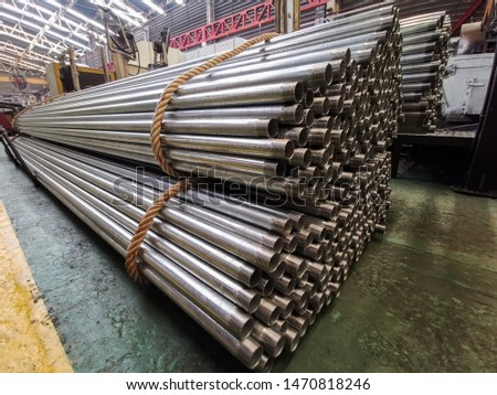Rows of Steel pipes bar storage and stacking in the warehouse for industrial construction. 