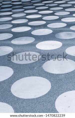 A concrete square with a symmetrical white circle pattern seen in perspective.