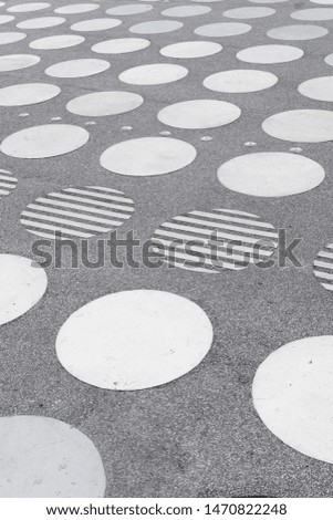 A concrete square with a symmetrical white circle pattern seen in perspective.