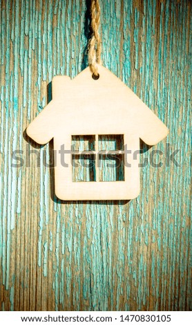 The symbol of the house hangs on a blue wooden background 