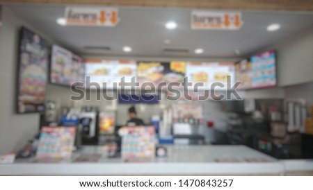 Lens blurred and Vintage of image to see food items at the counter selling fried chicken, junk food that the sales staff took the fried chicken to the plate. Or give to the buyer.
