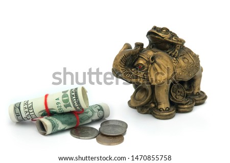 Money and a golden elephant with coins on which the toad sits on a white background. Feng Shui. Attracting money and huge wealth to the house.