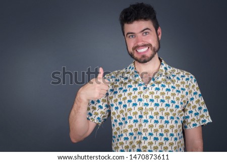 Good job! Portrait of a happy smiling blue eyed young successful man giving thumb up gesture standing outdoors. Positive human emotion facial expression body language. Funny girl