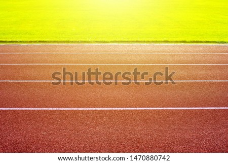 Green football field and Red Running track in stadium
